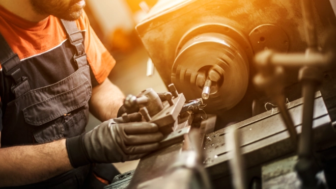 Male engineer drilling machine parts