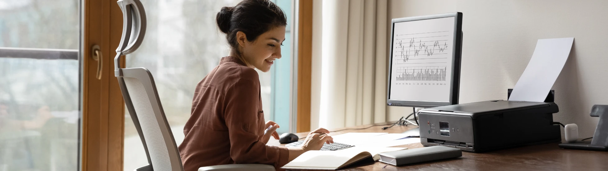 woman behind desk working on computer