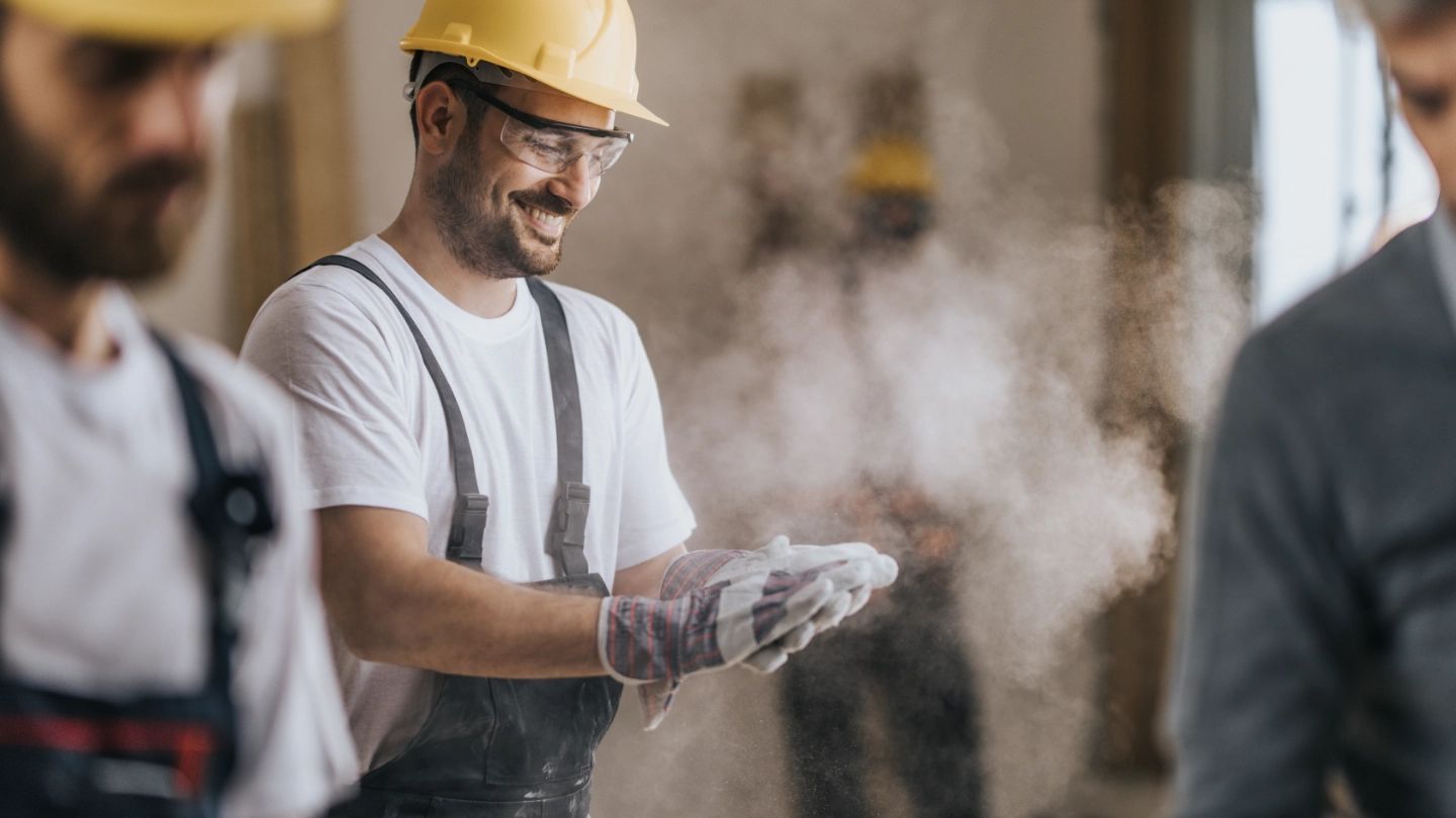 Happy construction worker with dusty gloves image