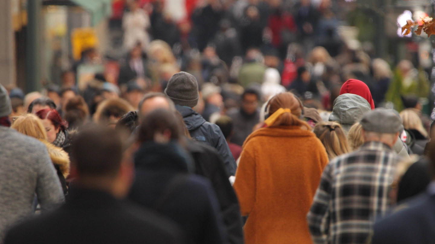 Crowd of people walking down a busy street