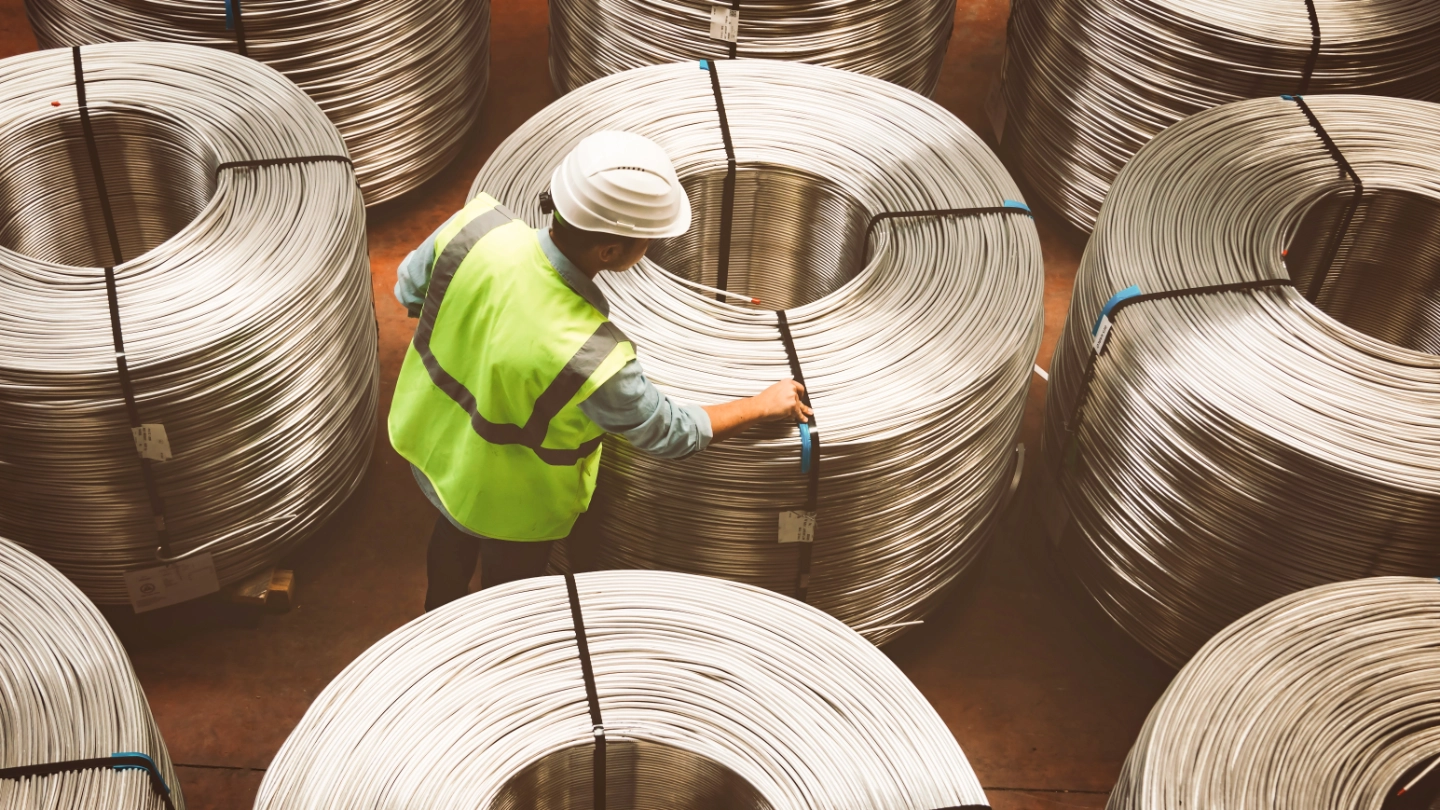 Male worker examining metal coils image