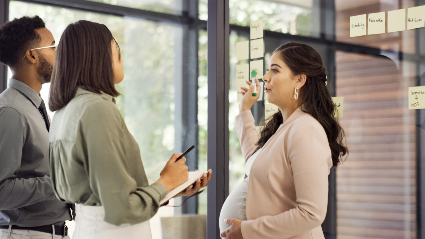 pregnant woman talking to woman and man